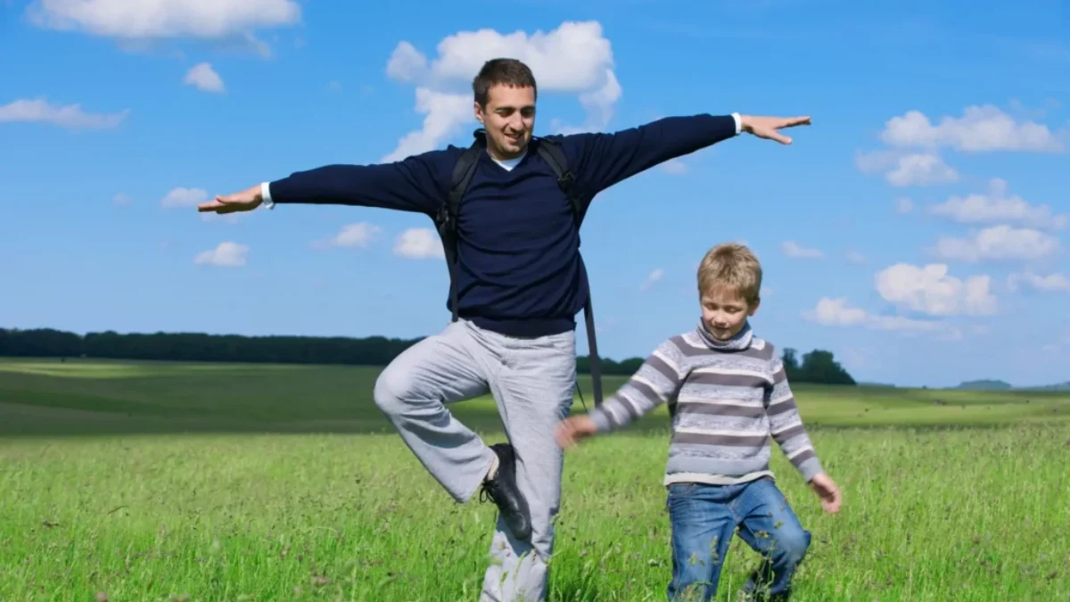 muž a dítě se snaží stát na jedné noze