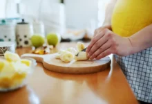 žena krájí na prkénku banán