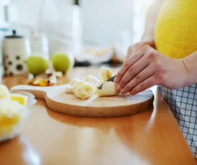 žena krájí na prkénku banán