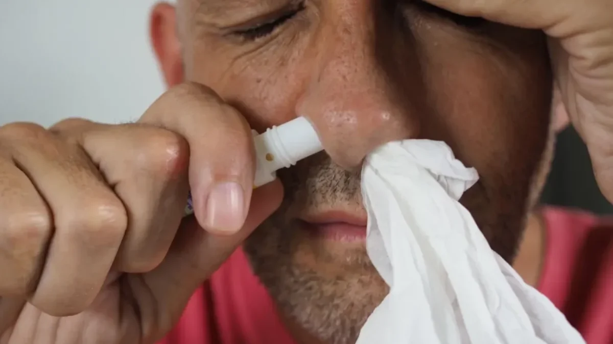 muž si stříká sprej do nosu