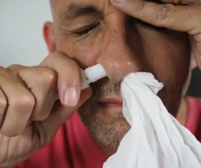 muž si stříká sprej do nosu