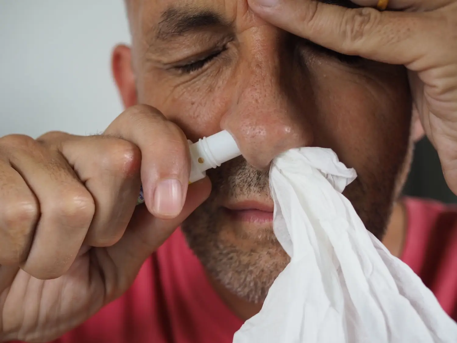 muž si stříká sprej do nosu