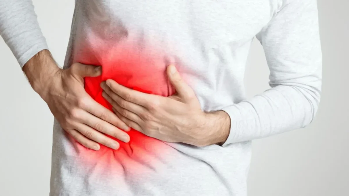 muž se drží pod žebry, pociťuje velkou bolest v oblasti jater