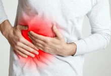 muž se drží pod žebry, pociťuje velkou bolest v oblasti jater