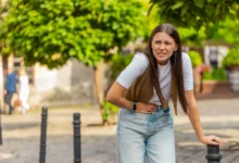 mladá dívka se drží za břicho