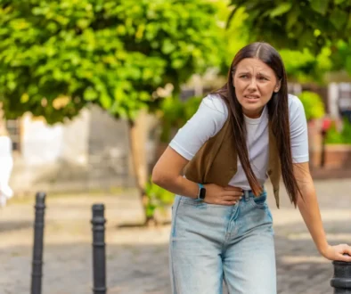 mladá dívka se drží za břicho