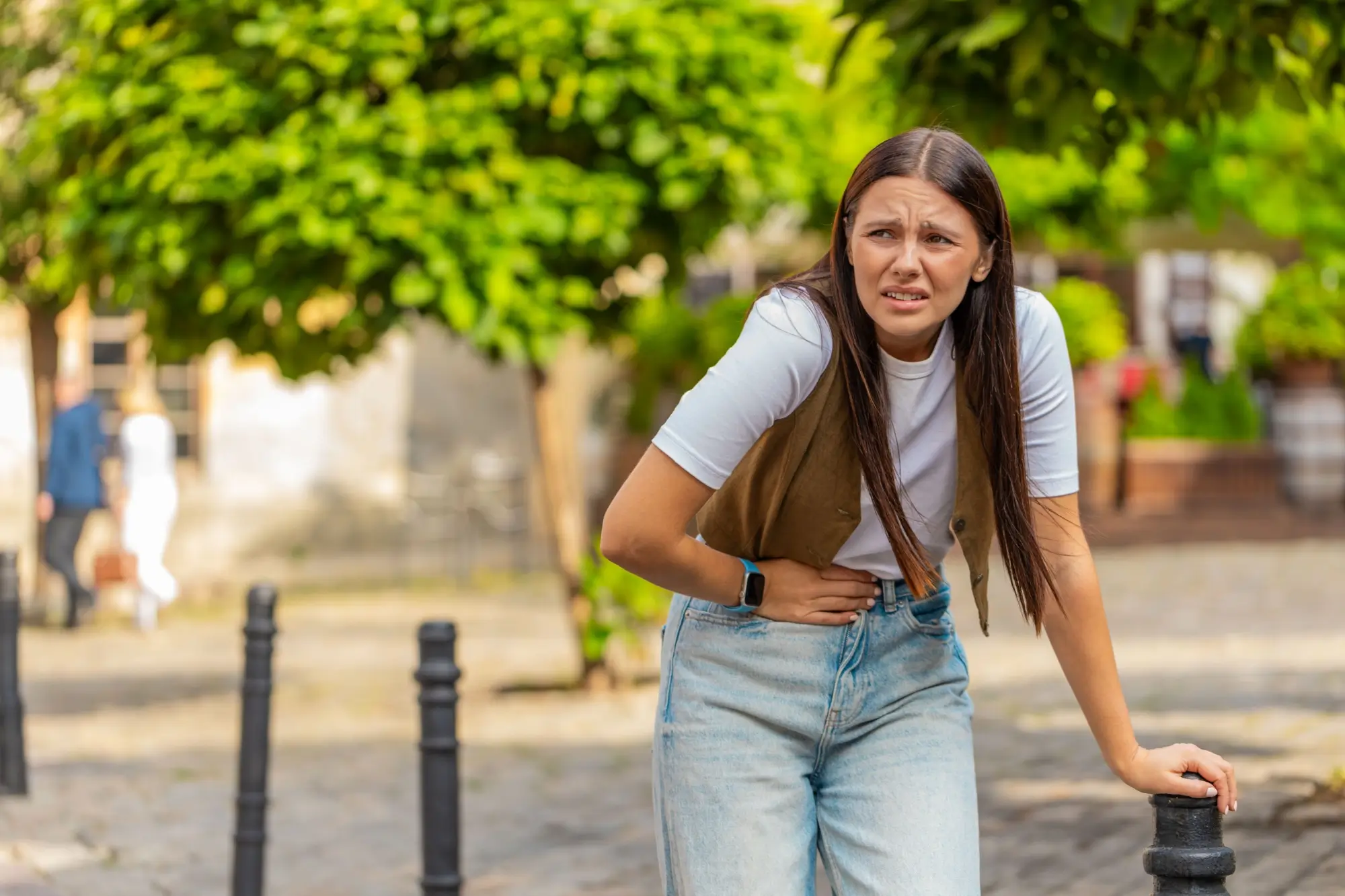 mladá dívka se drží za břicho