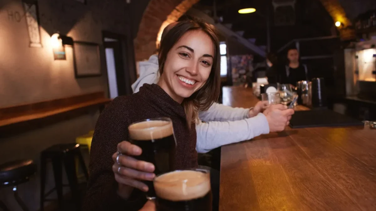 žena pije černé pivo