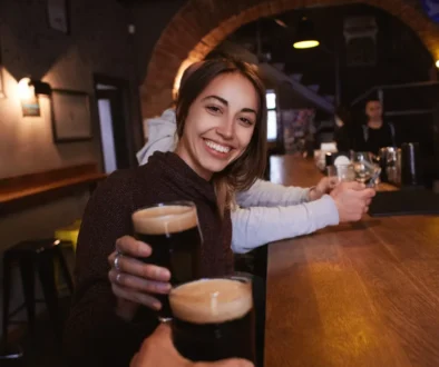 žena pije černé pivo