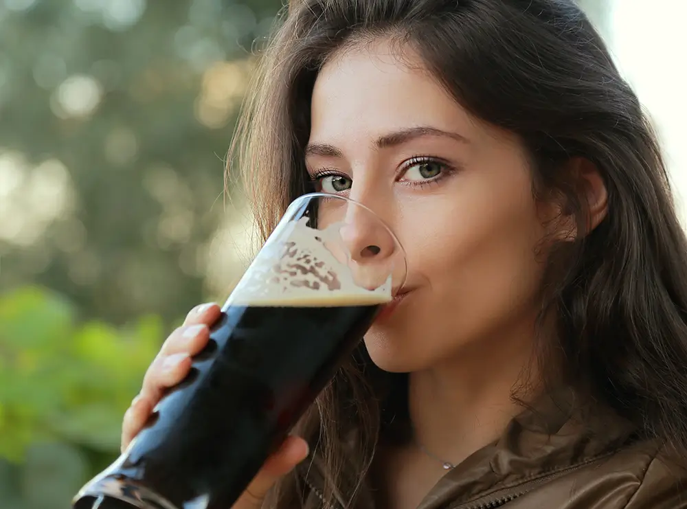 shutterstock_156034781 - SportDeník žena pije černé pivo