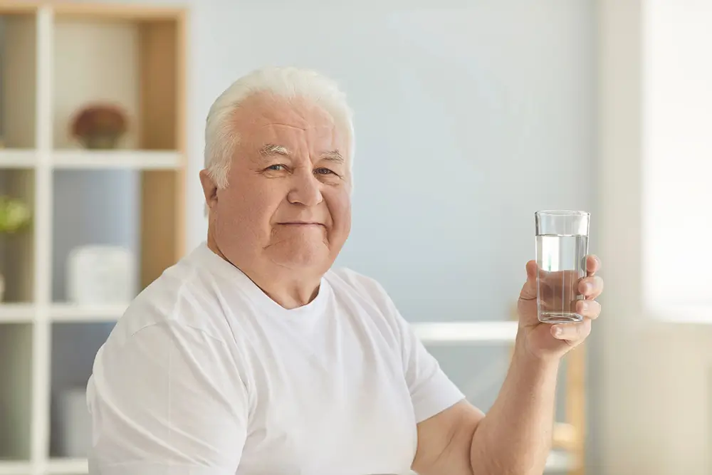 Slanou vodou můžete kloktat při bolestech v krku. - SportDeník muž drží v ruce sklenici se solí