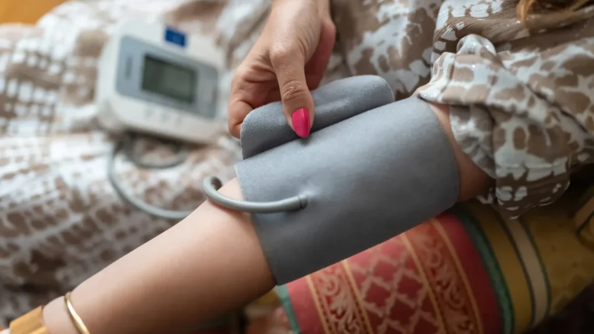 žena si měří tlak pomocí tlakoměru