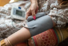 žena si měří tlak pomocí tlakoměru