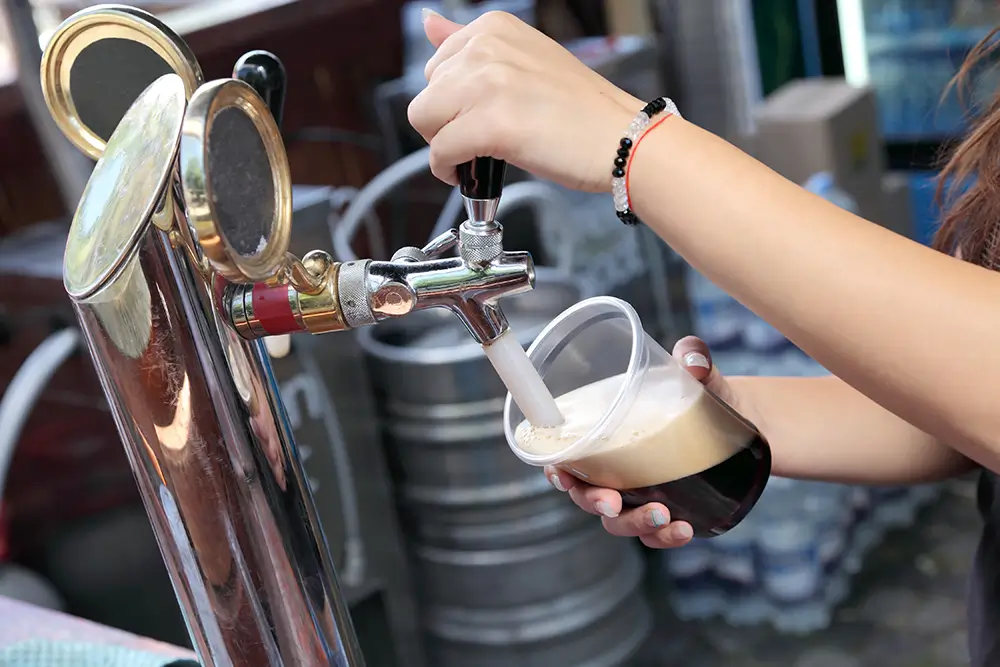 Tmavé pivo je díky vyššímu obsahu cukrů ještě vydatnější než pivo světlé. - SportDeník žena točí černé pivo